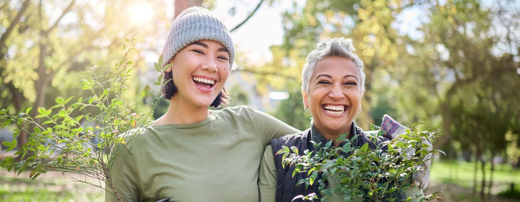 a couple of women holding plants