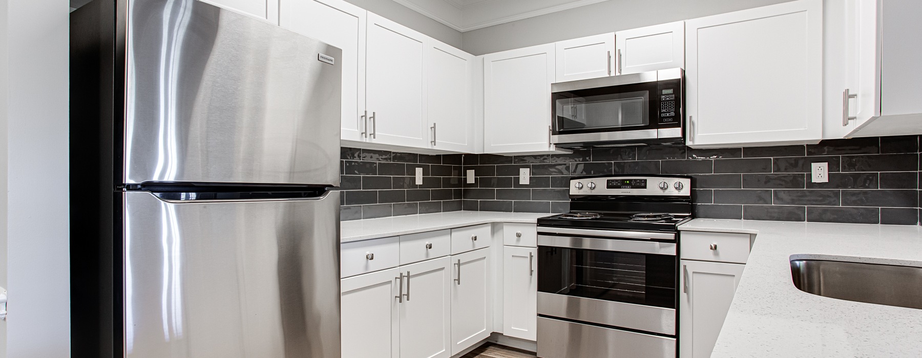 kitchen with white cabinets, quartz countertops, and stainless steel appliances