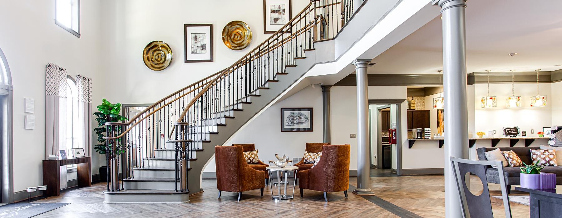 a large room with a wood floor and a wood staircase